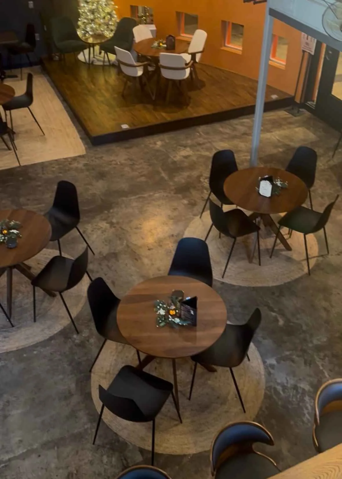 The dining room at Lee's Coffee, with round tables, lounge seating, and warm lighting